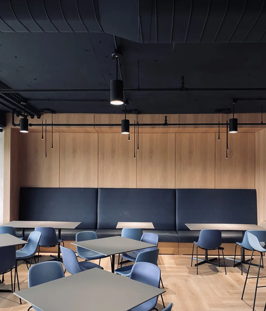 Full view of the commercial dining room showcasing the integrated restaurant wood paneling and seating layout.
