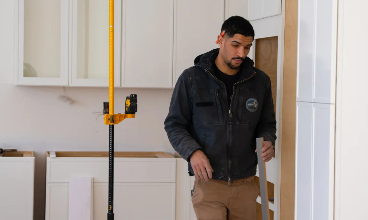 Technician carrying framing materials for the Custom Kitchen Cabinets NY installation.